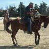Wade Brown helps roper by riding their horse with Roger Hanagriff in the background talking with a roper about her swing.